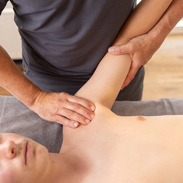 Patient und Therapeut bei Schulterbehandlung