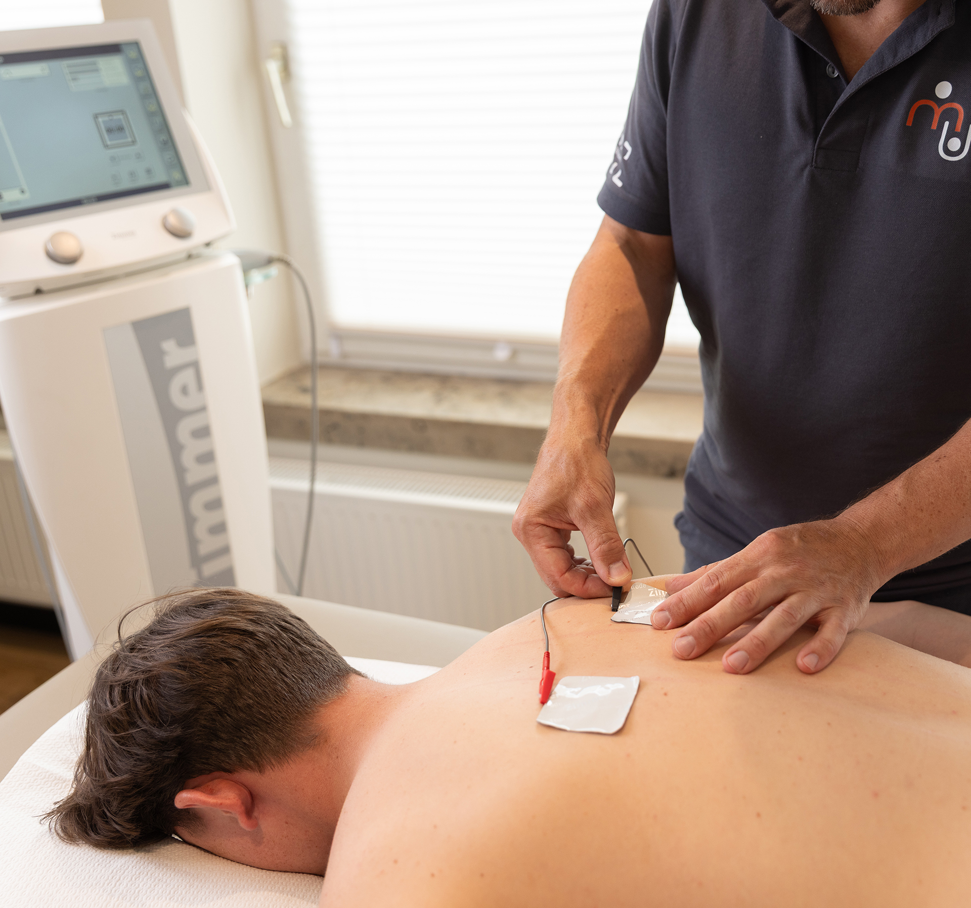 Patient bekommt am Rücken Sensoren aufgeklebt